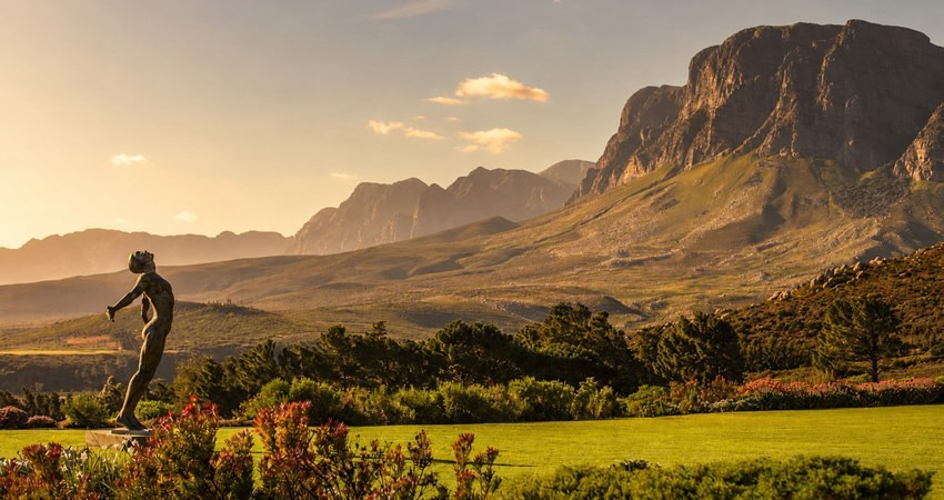 Late afternoon sun on the Helderberg mountain range above green lawns and fynbos